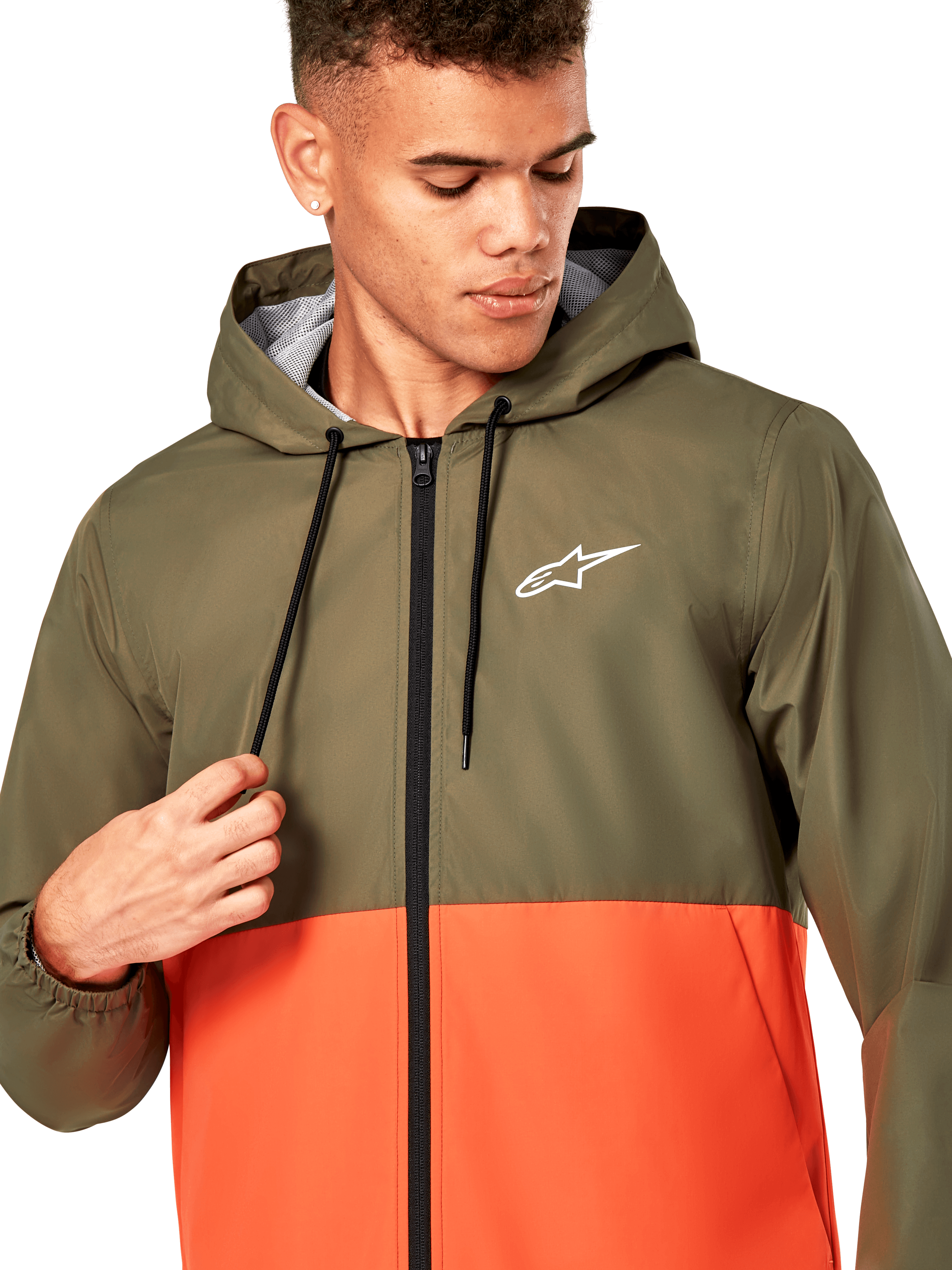 Alpinestars Speeder Windbreaker Jacket, giacca a vento leggera con cappuccio, design colorblock verde oliva e arancione militare, logo Alpinestars bianco sul petto, cerniera e cordoncini neri, abbigliamento sportivo casual ispirato al motorsport