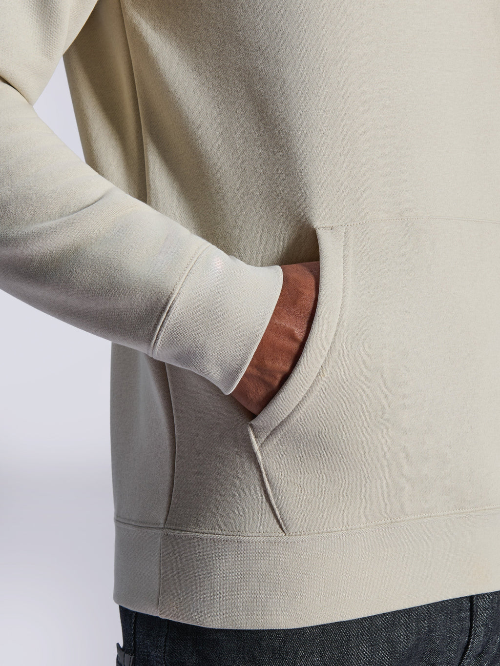 Alpinestars Ageless V3 Hoodie, dettaglio ravvicinato della tasca a marsupio frontale e del polsino a costine, pile bianco sporco, streetwear casual ispirato al motorsport