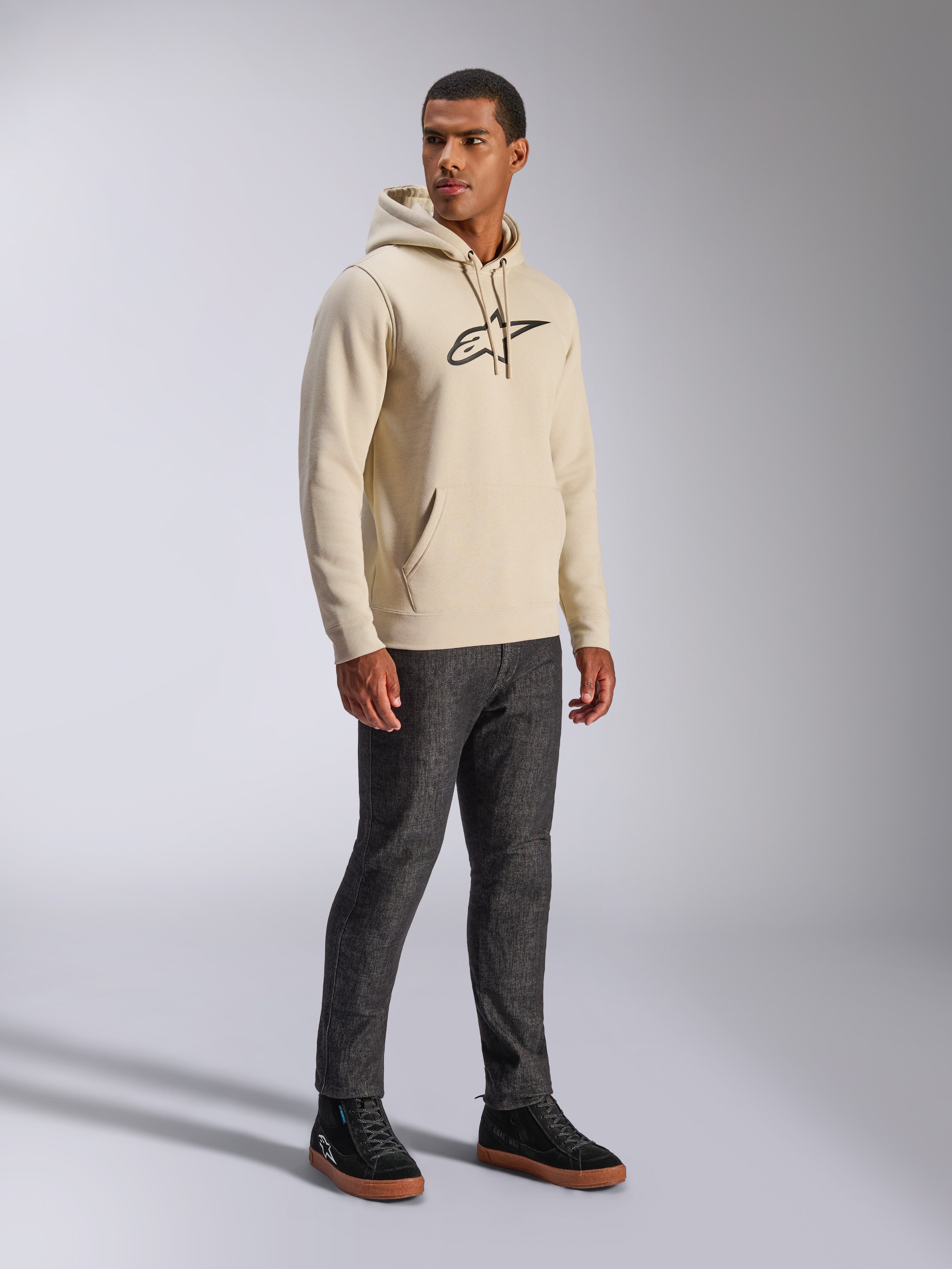 Alpinestars Ageless V3 Hoodie, streetwear casual, Off White con logo ricamato nero, felpa in pile con cappuccio, maniche lunghe, tasca a marsupio frontale, abbinata a jeans scuri e sneaker nere