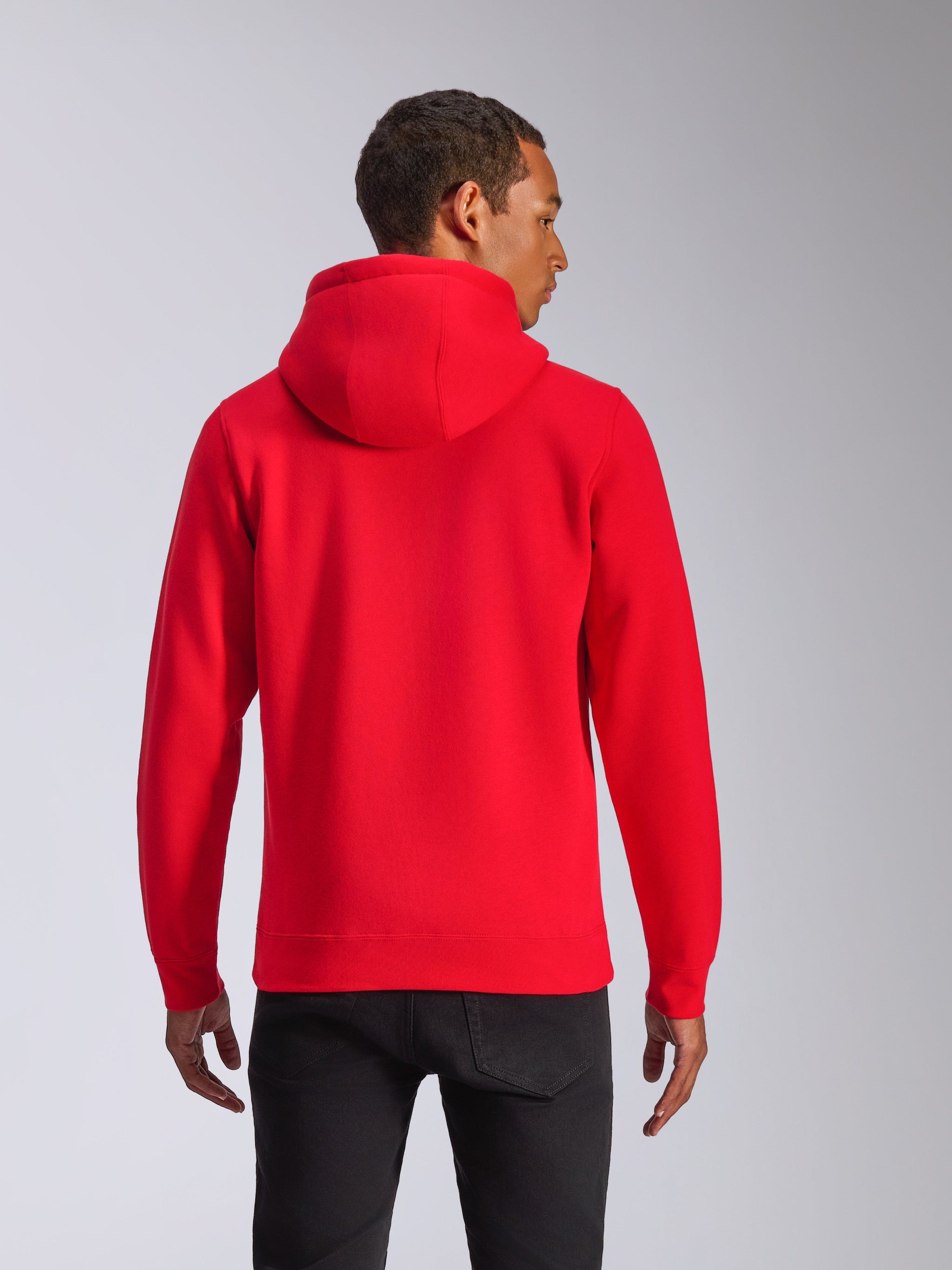 Alpinestars Ageless V3 Hoodie, vista posteriore, felpa rossa con cappuccio, abbigliamento sportivo casual con cappuccio foderato in jersey e polsini a coste, indossata da un modello con pantaloni neri