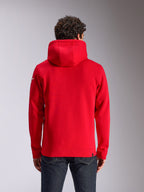 Alpinestars Linear Wordmark V3 Hoodie, vista posteriore di una felpa rossa con cappuccio, con logo Ageless bianco sulla manica, polsini e orlo a coste, streetwear casual ispirato al motorsport