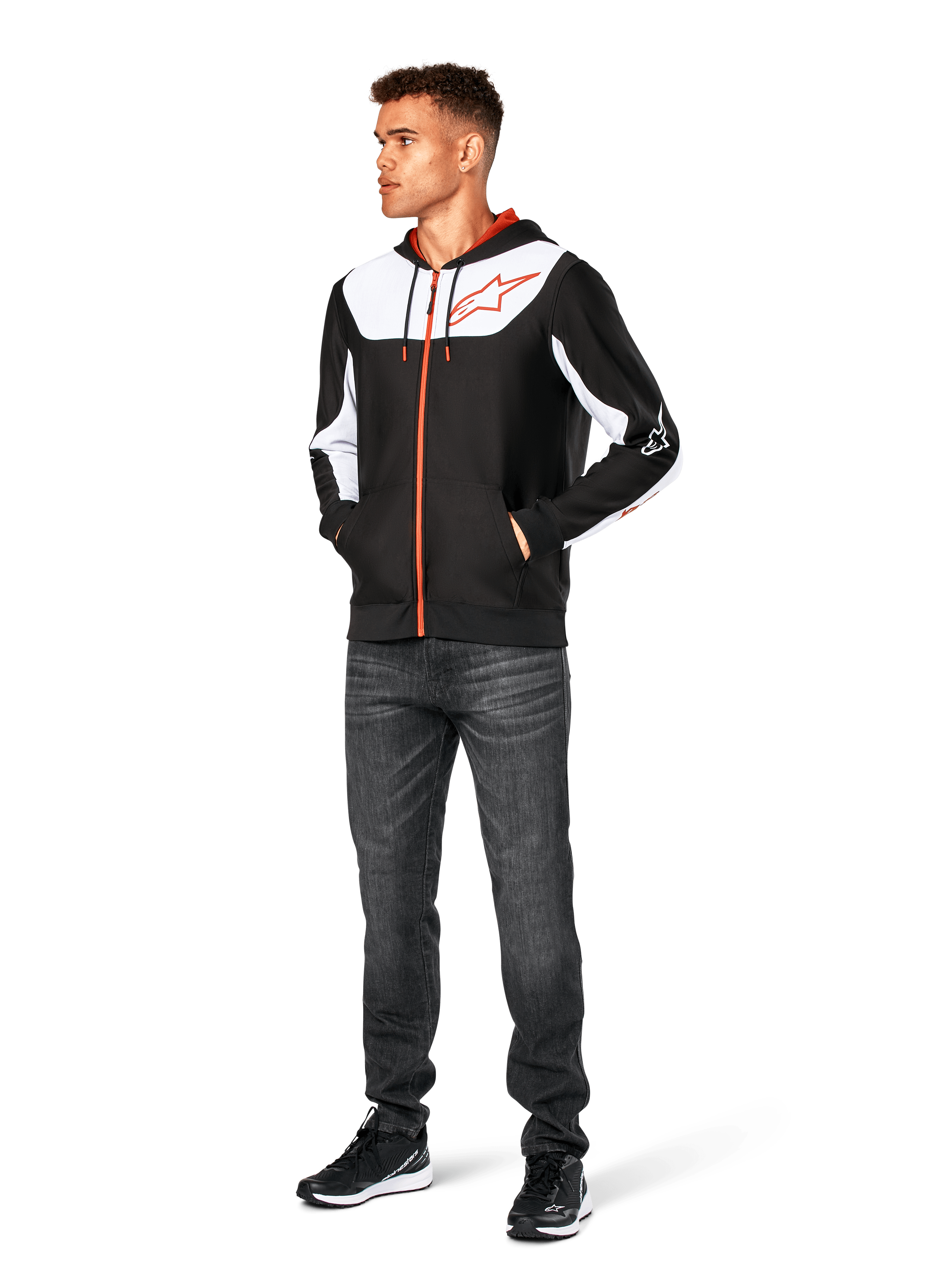 Felpa con cappuccio Alpinestars Sessions V3, felpa casual con zip frontale, nero, bianco e rosso, indossata da un modello con jeans scuri e sneakers nere, caratterizzata da pannelli color-block bianchi sul petto e sulle maniche, dettagli della zip e dei cordini rossi, grande logo sul petto, streetwear in pile di poliestere ispirato al motorsport.