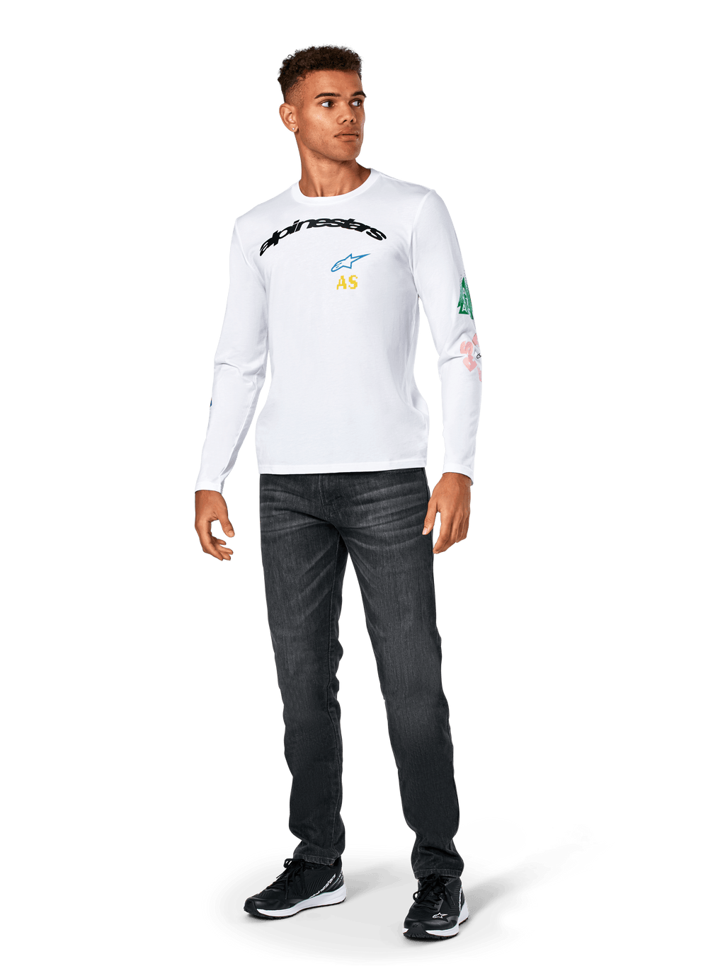 Alpinestars Brundo CSF Tee - Long Sleeve, maglietta a maniche lunghe, bianca, abbigliamento sportivo casual, con scritta 'alpinestars' nera sul petto, logo a stella blu e iniziali 'AS' gialle, grafiche colorate sulla manica, indossata con jeans scuri e sneakers nere