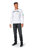 Alpinestars Brundo CSF Tee - Long Sleeve, maglietta a maniche lunghe, bianca, abbigliamento sportivo casual, con scritta 'alpinestars' nera sul petto, logo a stella blu e iniziali 'AS' gialle, grafiche colorate sulla manica, indossata con jeans scuri e sneakers nere