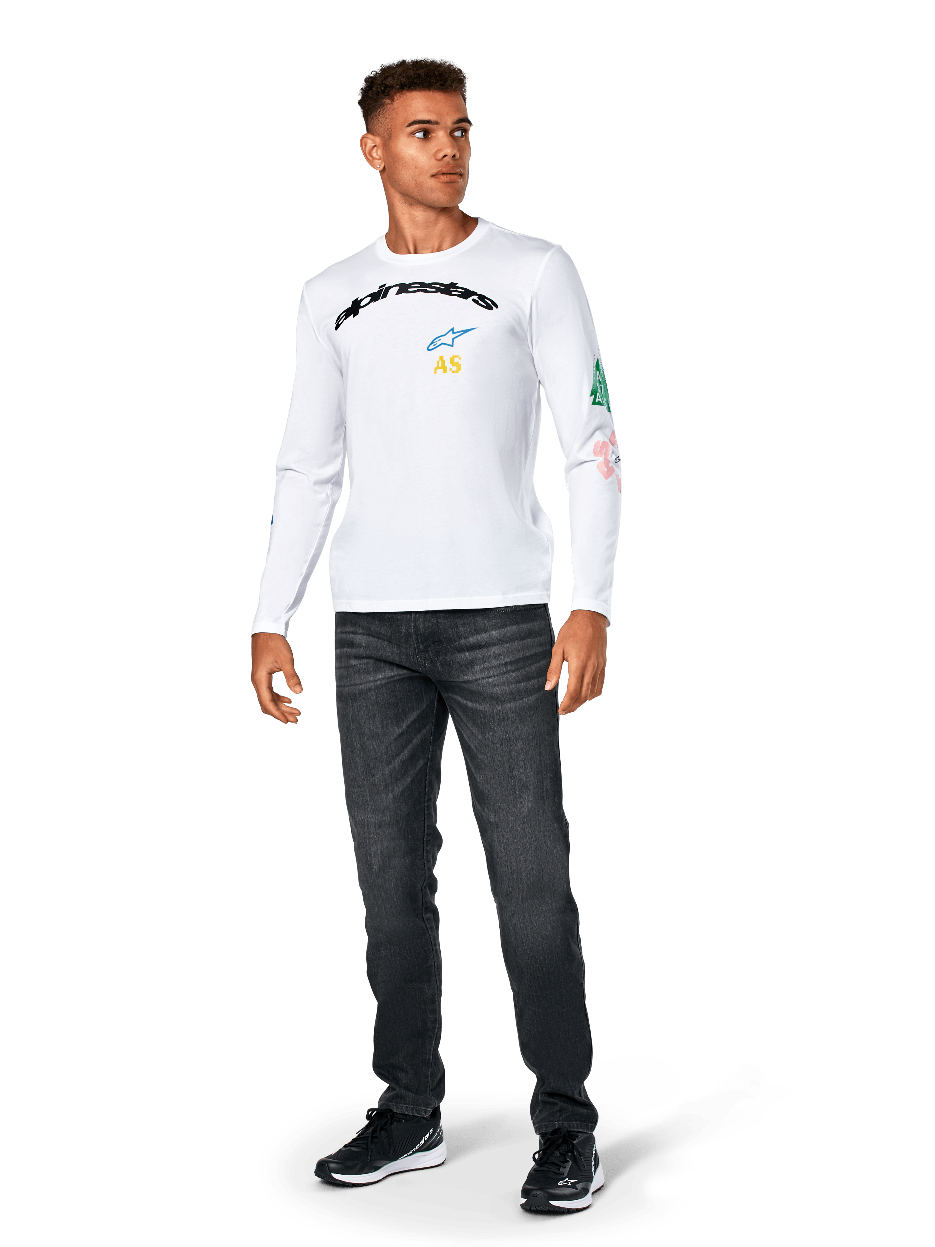 Alpinestars Brundo CSF Tee - Long Sleeve, maglietta a maniche lunghe, bianca, abbigliamento sportivo casual, con scritta 'alpinestars' nera sul petto, logo a stella blu e iniziali 'AS' gialle, grafiche colorate sulla manica, indossata con jeans scuri e sneakers nere