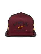 Cappellino Alpinestars Backline Trucker, snapback con visiera piatta, parte anteriore in twill rosso mattone con retro in rete nera, logo e strisce laterali giallo senape, corona strutturata con rifinitura suttache sulla visiera, streetwear casual motorsport