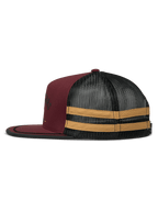 Cappellino Trucker Alpinestars Backline, vista laterale di profilo, colore Brick Black e Mustard, parte anteriore in twill bordeaux con retro in rete nera, strisce orizzontali color senape sul lato, visiera piatta con bordo nero, snapback casual ispirato al motorsport