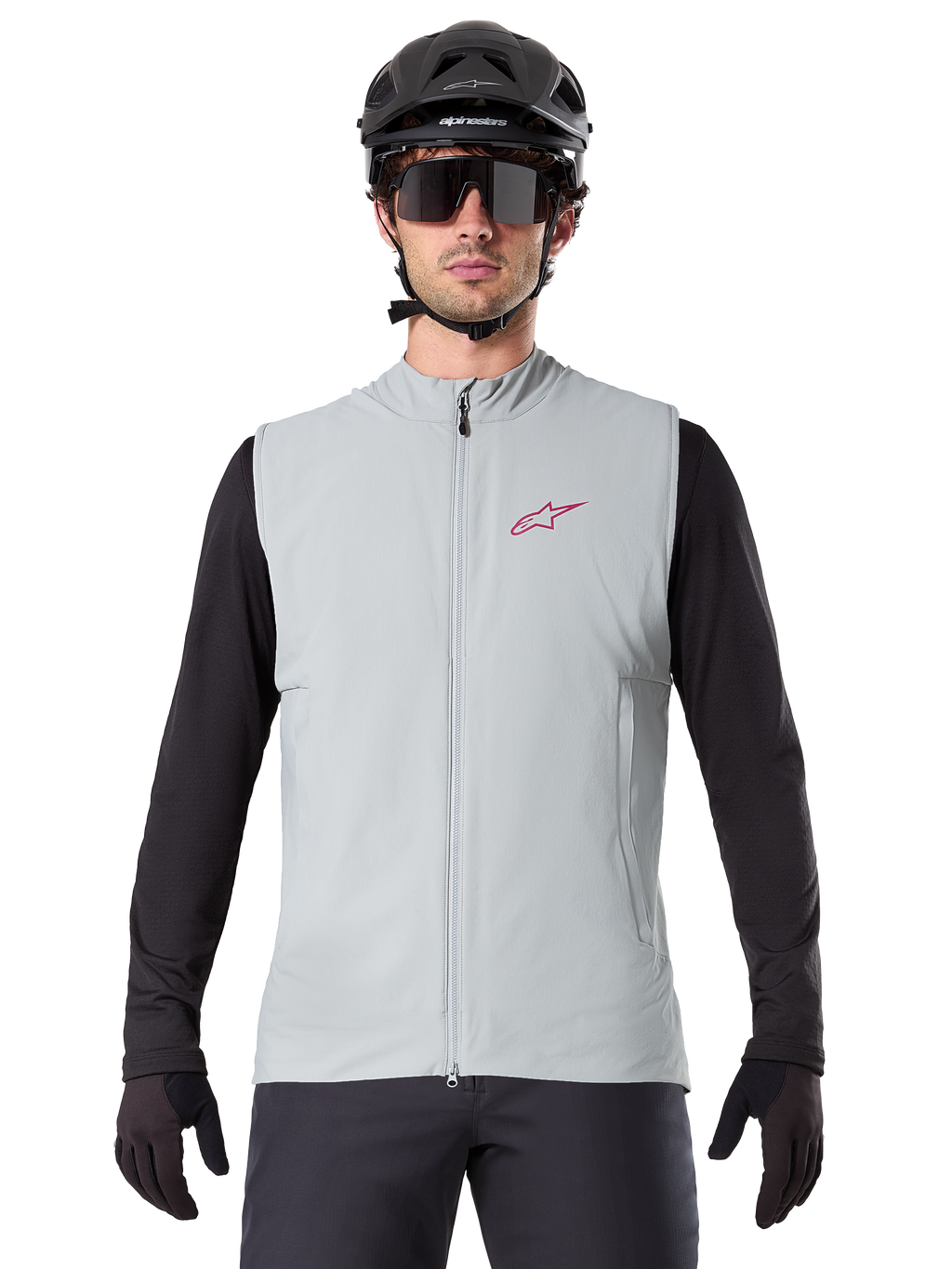 Gilet termico Alpinestars A-Dura, gilet da ciclismo, grigio titanio, indossato con una maglia a maniche lunghe nera e un casco da ciclismo nero, logo a stella Alpinestars rosso sul petto, leggero e isolato per la mountain bike.
