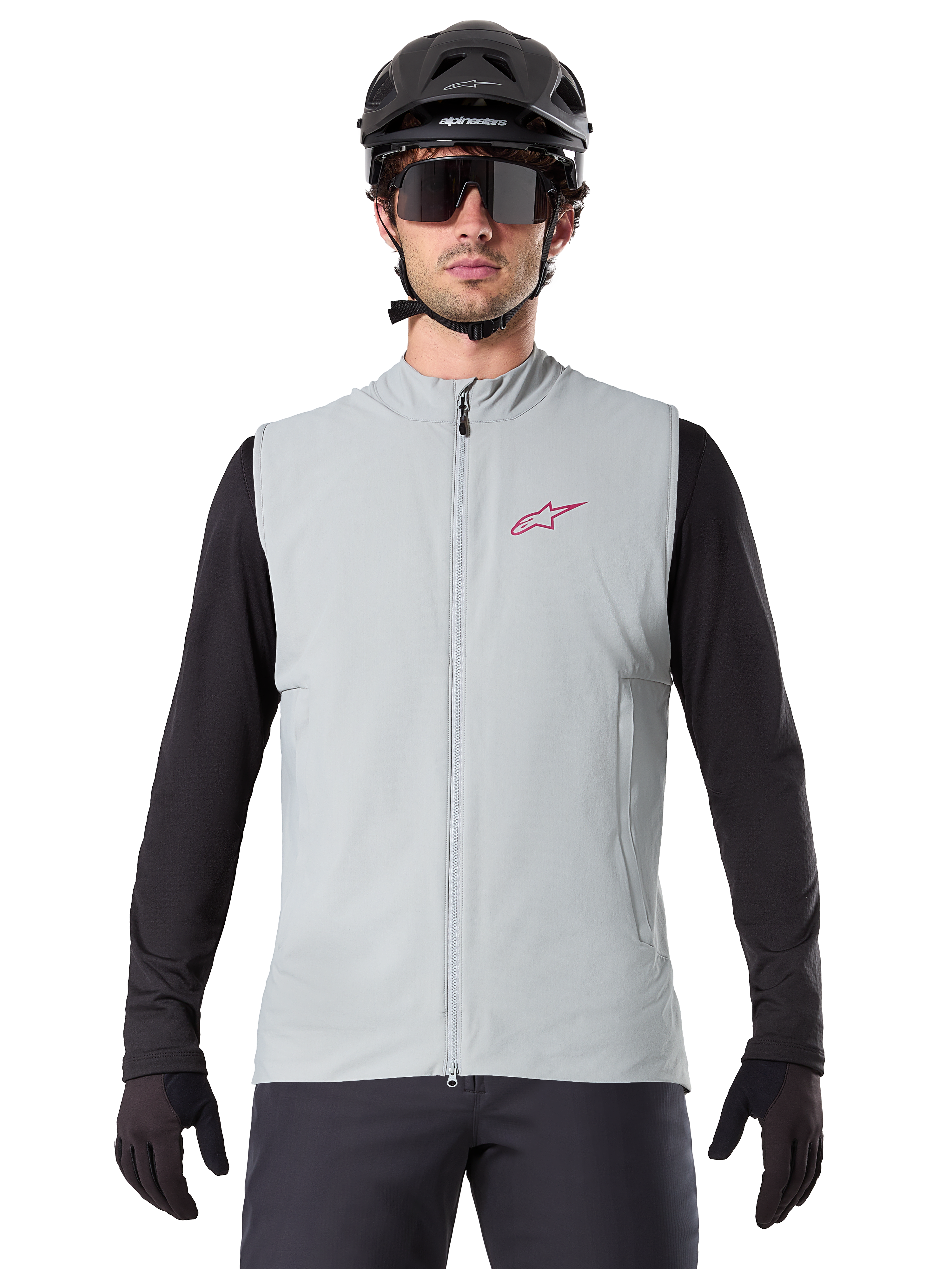 Gilet termico Alpinestars A-Dura, gilet da ciclismo, grigio titanio, indossato con una maglia a maniche lunghe nera e un casco da ciclismo nero, logo a stella Alpinestars rosso sul petto, leggero e isolato per la mountain bike.