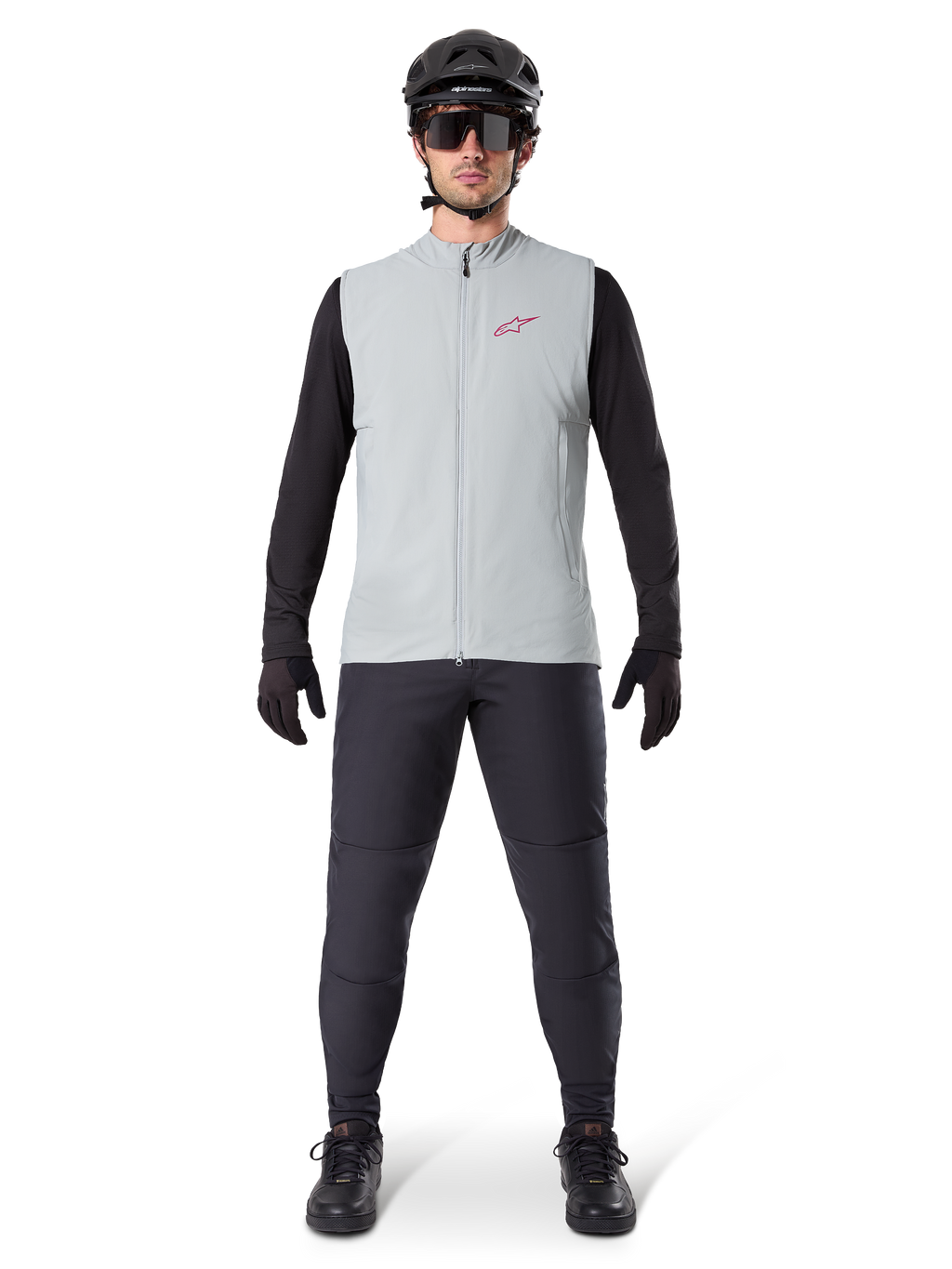 Alpinestars A-Dura Thermal Vest, gilet da ciclismo, grigio titanio, indossato con maglia a maniche lunghe nera e pantaloni neri, casco nero e occhiali da sole, con logo Alpinestars rosso, isolamento termico leggero per mountain bike