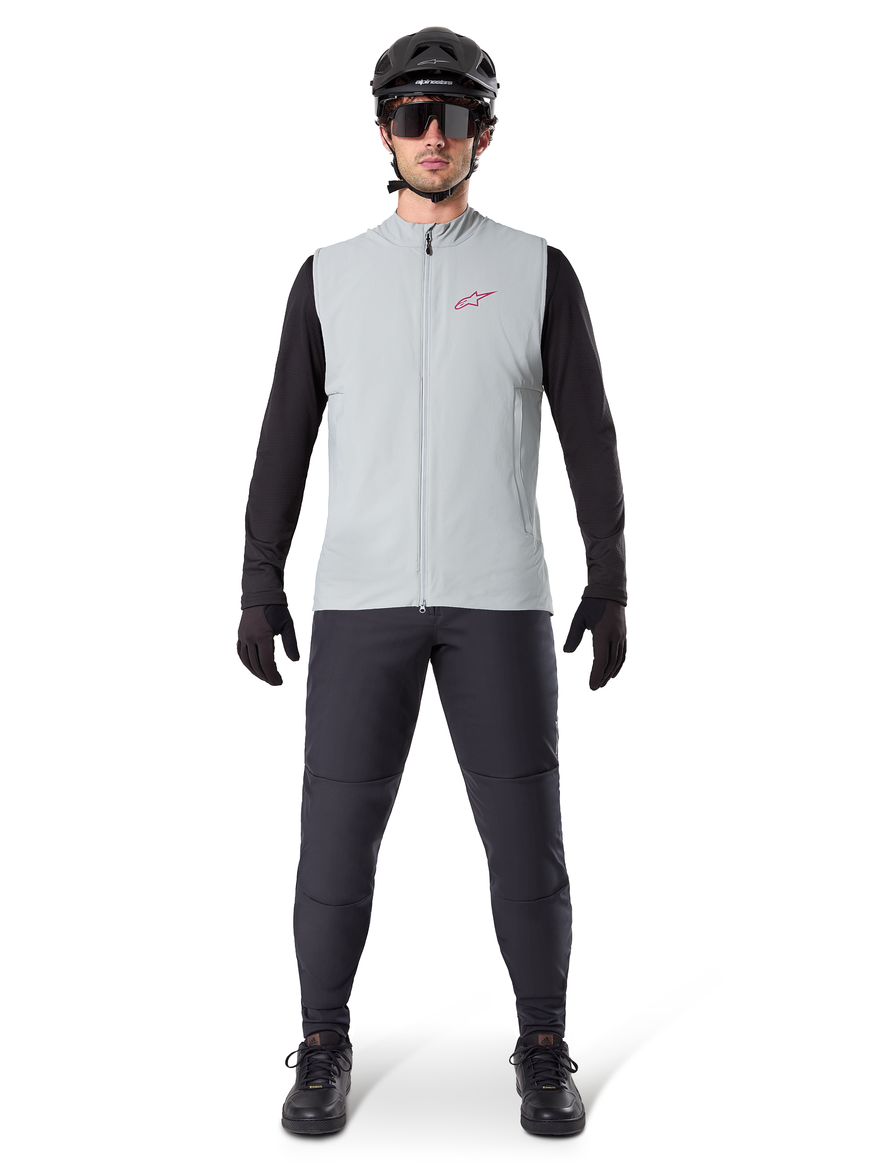 Alpinestars A-Dura Thermal Vest, gilet da ciclismo, grigio titanio, indossato con maglia a maniche lunghe nera e pantaloni neri, casco nero e occhiali da sole, con logo Alpinestars rosso, isolamento termico leggero per mountain bike