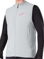 Gilet Termico Alpinestars A-Dura, gilet da ciclismo isolato in grigio titanio, con logo a stella rosa sul petto, indossato sopra una maglia nera a maniche lunghe, include una tasca verticale con cerniera e zip frontale completa, progettato per mountain bike in condizioni di freddo