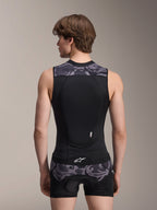 Gilet protettivo Alpinestars A-Motion Plasma, Black Camo, vista posteriore su modello uomo, con costruzione in mesh traspirante, paraschiena Nucleon Plasma integrato, dettagli mimetici grigi su spalle e vita e logo Alpinestars.
