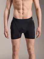 Alpinestars A-Motion Plasma Protection Boxers, pantaloncini protettivi MTB, neri con dettagli Black Camo, vista frontale su modello maschile, in rete elastica traspirante e protezione integrata per i fianchi per prestazioni ciclistiche.
