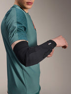 Alpinestars A-Motion Plasma Elbow Sleeve, protezione gomito da ciclismo, nero, indossata da un rider con maglia verde acqua, con logo Alpinestars e marchio Nucleon Plasma, design sottile e traspirante per protezione MTB