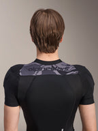 Alpinestars A-Motion Plasma Protection Jacket - Manica Corta, vista posteriore della parte superiore del busto, nero con pannello camo grigio sulle spalle e logo Alpinestars, struttura in mesh elasticizzato traspirante per protezione MTB