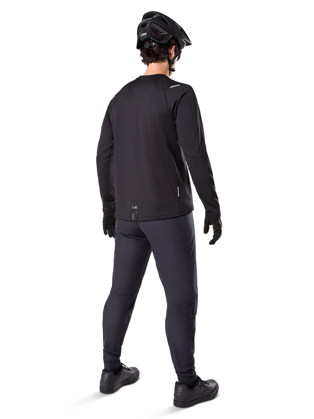 Alpinestars A-Dura Thermal Pant, pantaloni da mountain bike, nero, vista posteriore, indossati con maglia a maniche lunghe coordinata, casco da MTB nero e guanti, abbigliamento tecnico da ciclismo per climi freddi