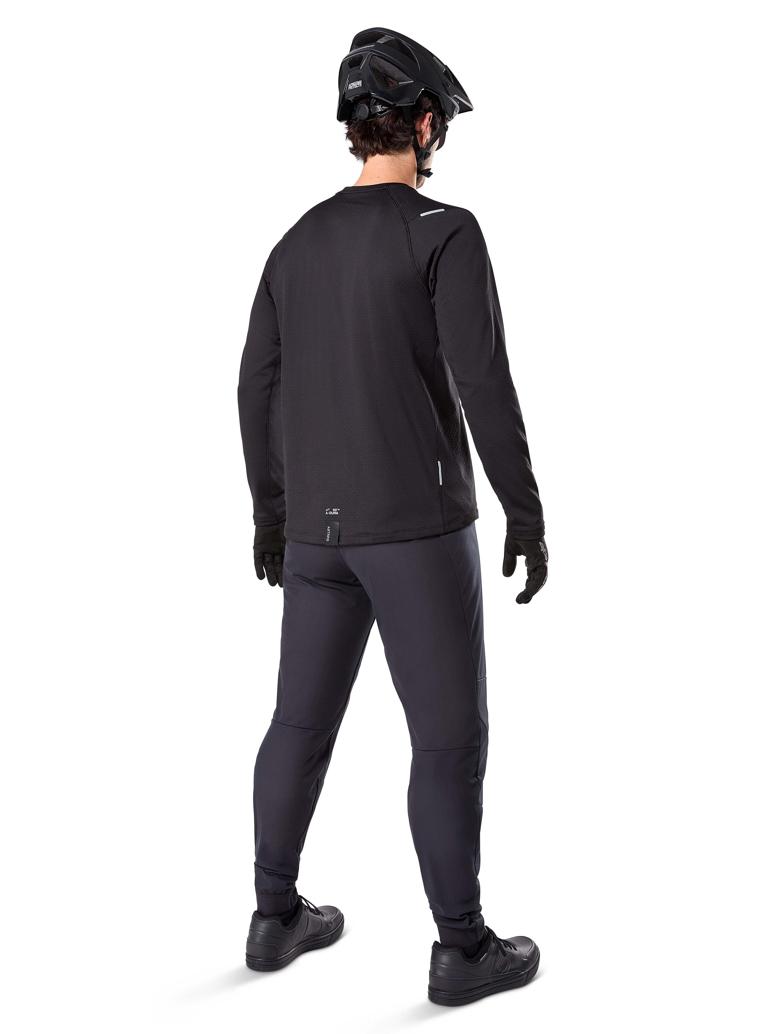 Alpinestars A-Dura Thermal Pant, pantaloni da mountain bike, nero, vista posteriore, indossati con maglia a maniche lunghe coordinata, casco da MTB nero e guanti, abbigliamento tecnico da ciclismo per climi freddi