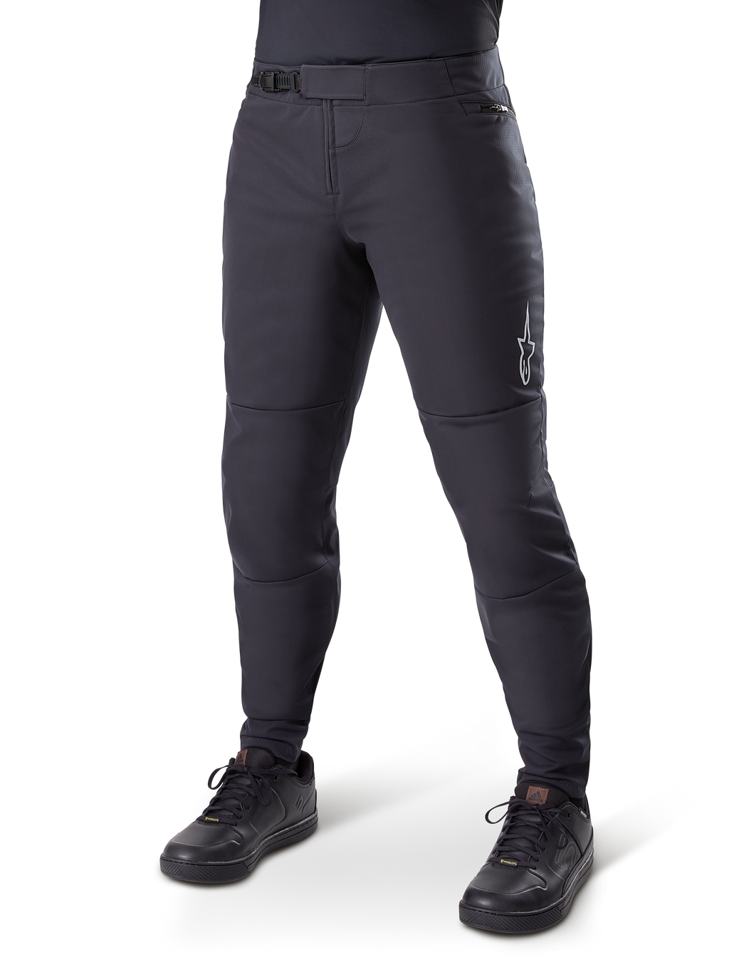 Alpinestars A-Dura Thermal Pant, pantaloni da mountain bike neri, indossati con scarpe da ciclismo nere, con chiusura a cricchetto in vita, piccolo logo bianco sulla coscia e vestibilità affusolata per la guida in climi freddi