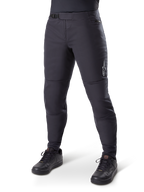 Alpinestars A-Dura Thermal Pant, pantaloni da mountain bike neri, indossati con scarpe da ciclismo nere, con chiusura a cricchetto in vita, piccolo logo bianco sulla coscia e vestibilità affusolata per la guida in climi freddi