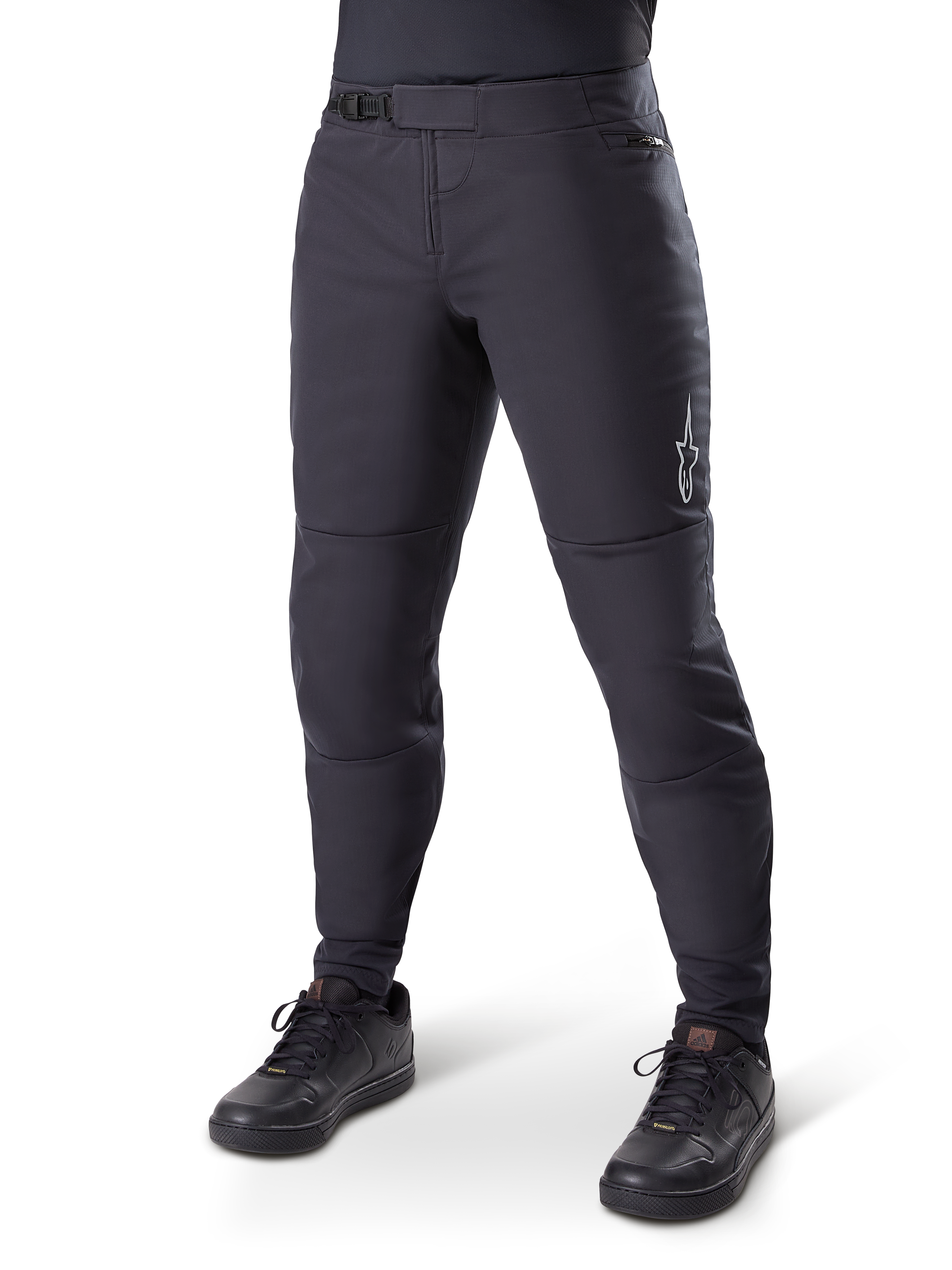 Alpinestars A-Dura Thermal Pant, pantaloni da mountain bike neri, indossati con scarpe da ciclismo nere, con chiusura a cricchetto in vita, piccolo logo bianco sulla coscia e vestibilità affusolata per la guida in climi freddi