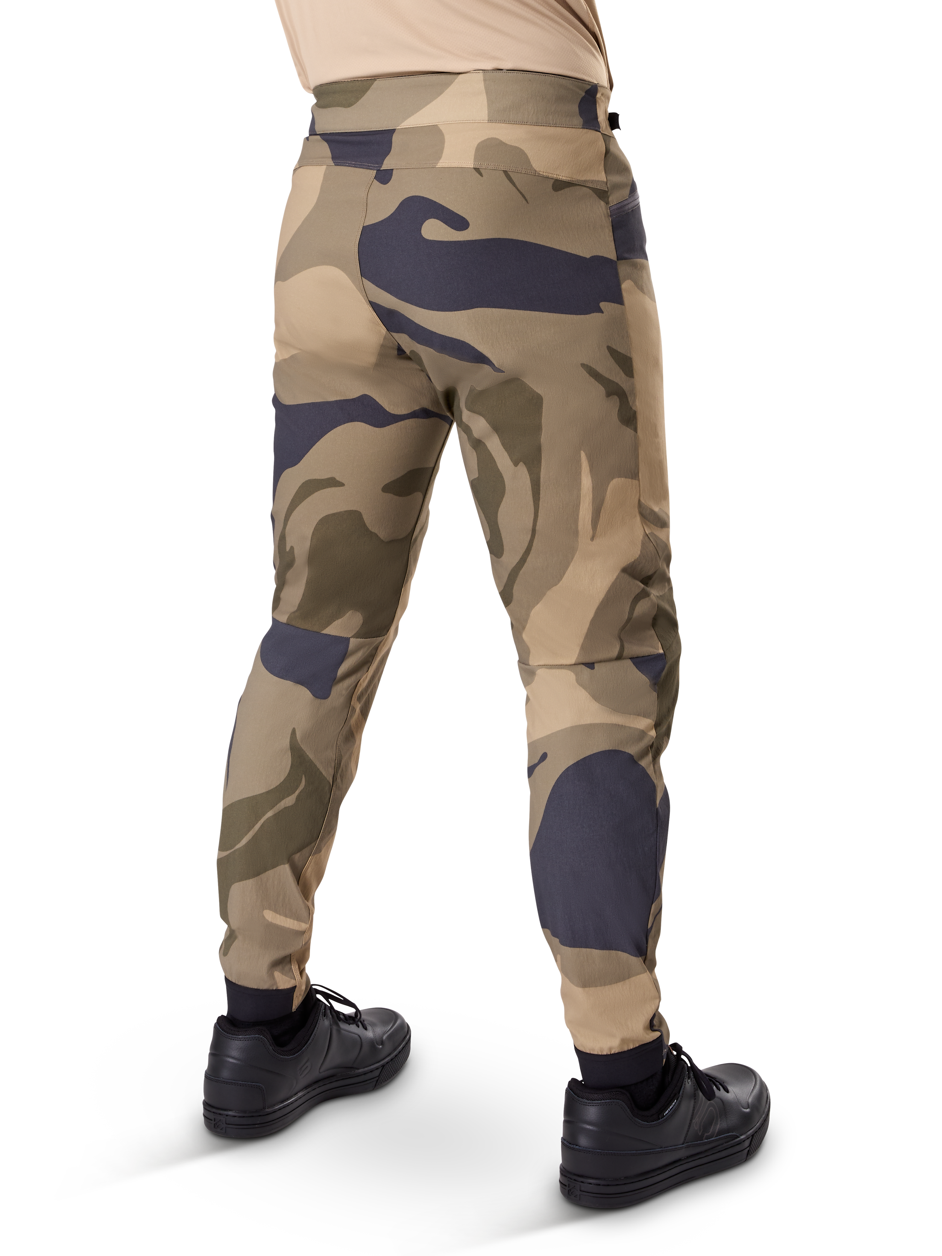 Alpinestars A-Dura Camo Pant, pantaloni MTB, motivo mimetico marrone con accenti sabbia e grigio scuro, vista posteriore con sneaker nere, gambe affusolate e polsini elasticizzati, tessuto resistente elasticizzato in 2 direzioni per mountain bike