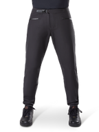 Pantaloni impermeabili Alpinestars A-Dura, nero, pantaloni da mountain bike con chiusura a cricchetto in vita e tasche con cerniera, vista frontale su modello abbinati a scarpe nere, abbigliamento impermeabile resistente per MTB