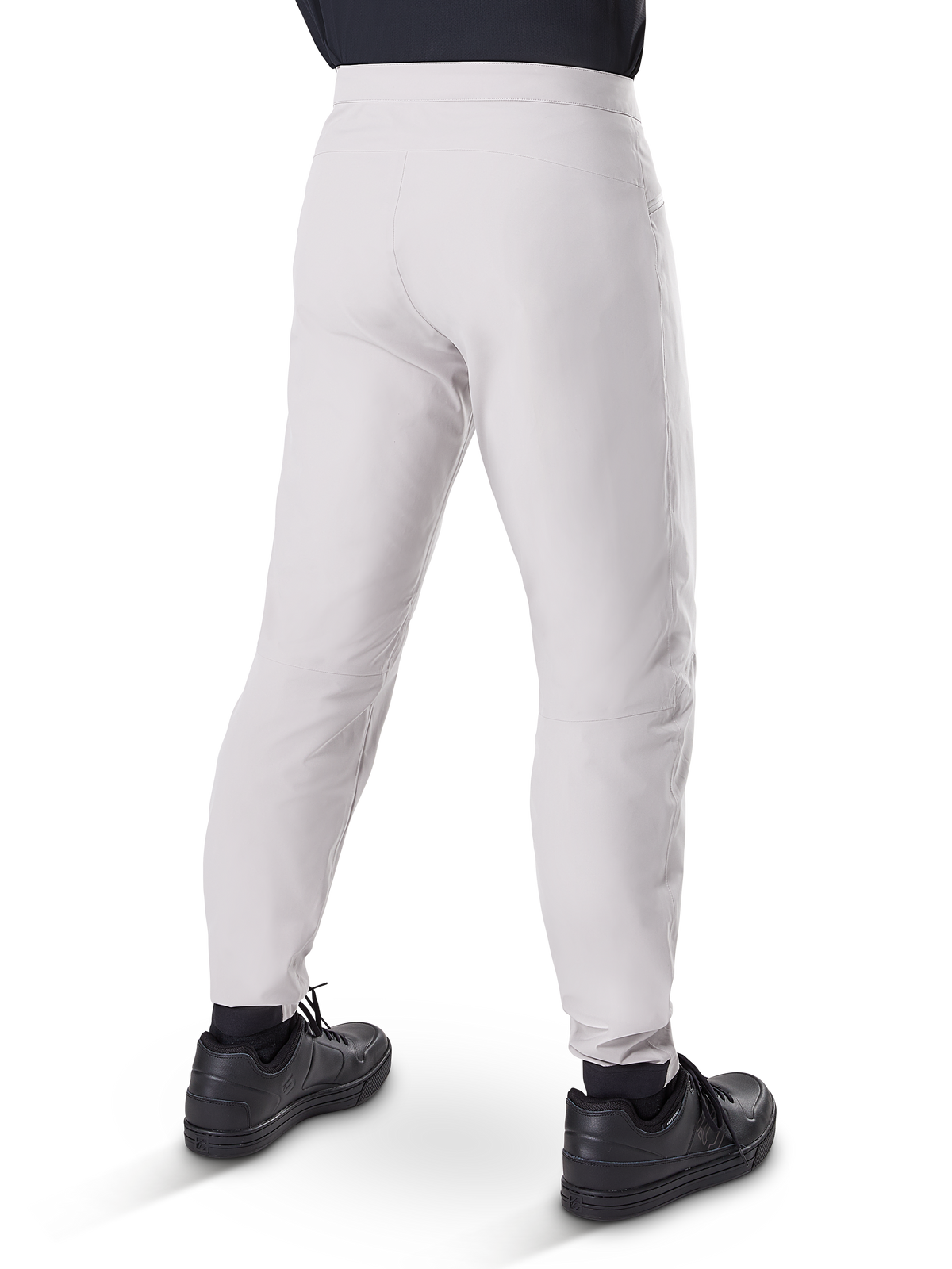 Alpinestars Pantaloni Impermeabili A-Dura, pantaloni da ciclismo MTB, grigio titanio, vista posteriore con gambe affusolate e polsini elasticizzati, indossati con scarpe nere, abbigliamento tecnico impermeabile per mountain bike