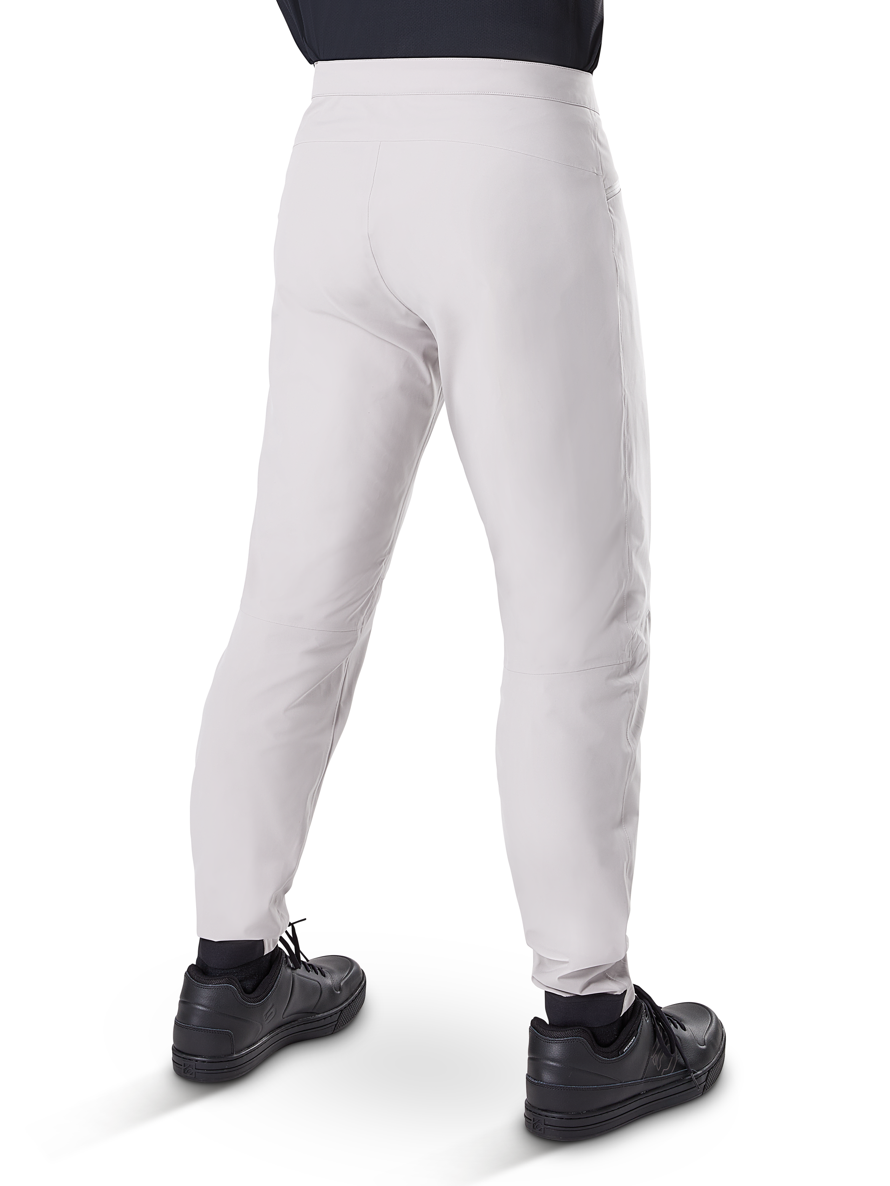 Alpinestars Pantaloni Impermeabili A-Dura, pantaloni da ciclismo MTB, grigio titanio, vista posteriore con gambe affusolate e polsini elasticizzati, indossati con scarpe nere, abbigliamento tecnico impermeabile per mountain bike