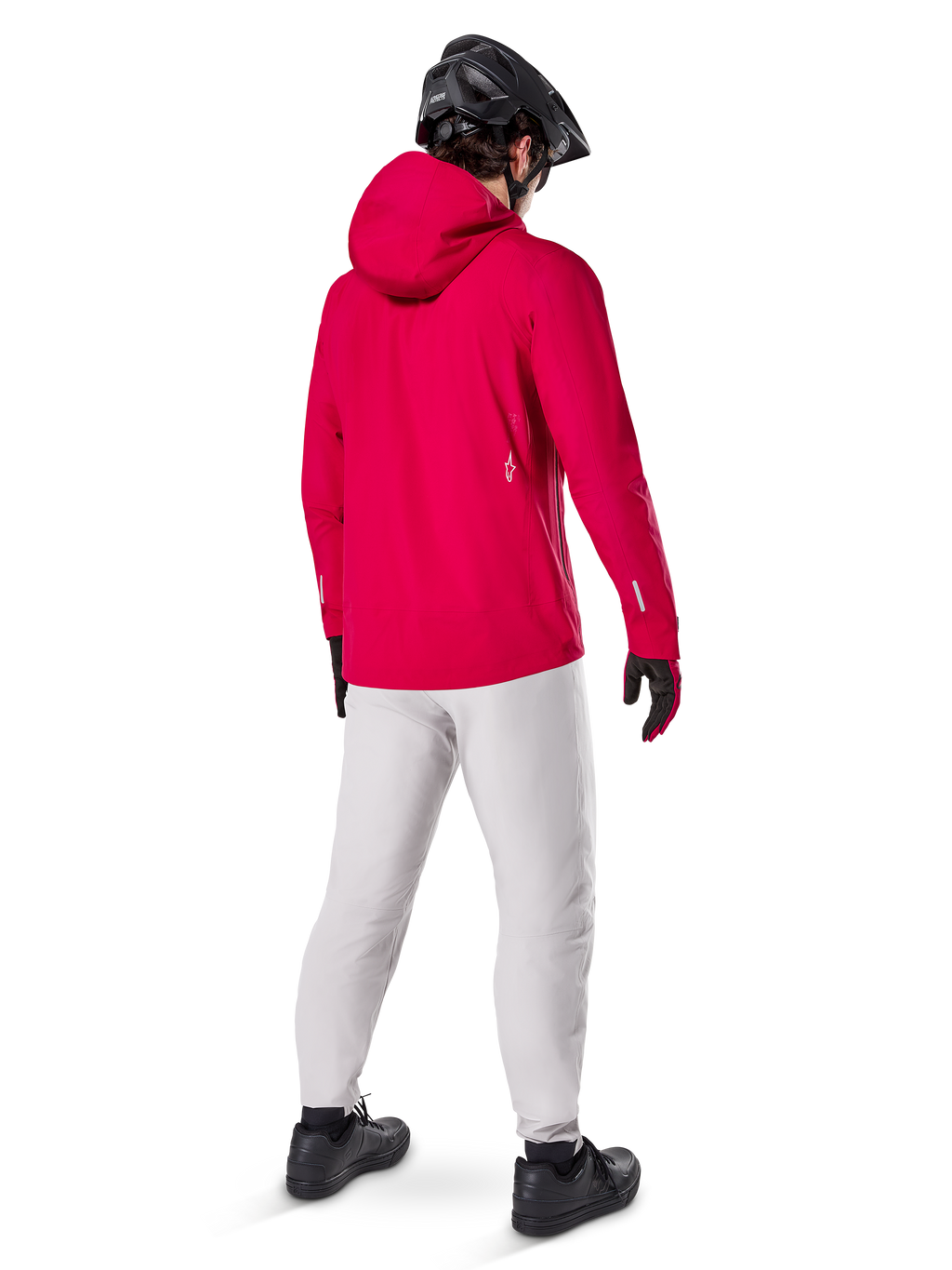 Pantaloni impermeabili Alpinestars A-Dura in Titanium, vista posteriore di un rider che indossa i pantaloni tecnici da mountain bike grigio chiaro con una giacca rossa con cappuccio e casco nero, abbigliamento impermeabile e resistente per il ciclismo in condizioni di bagnato