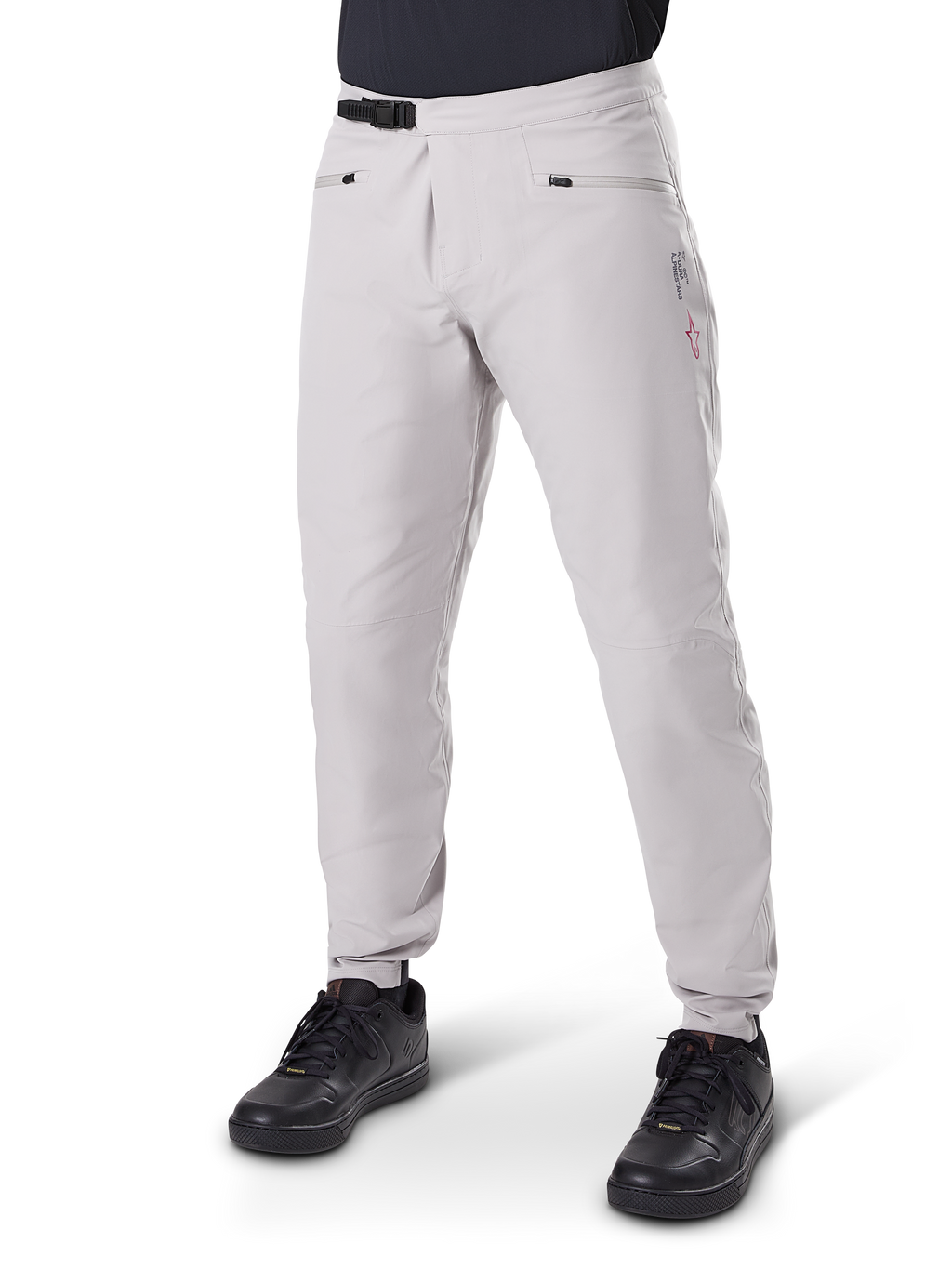 Alpinestars A-Dura Waterproof Pants, pantaloni impermeabili da mountain bike, grigio titanio, con chiusura a cricchetto nera in vita e tasche con zip, gambe affusolate con polsini elastici, indossati con scarpe nere, costruzione impermeabile 3L per ciclismo fuoristrada