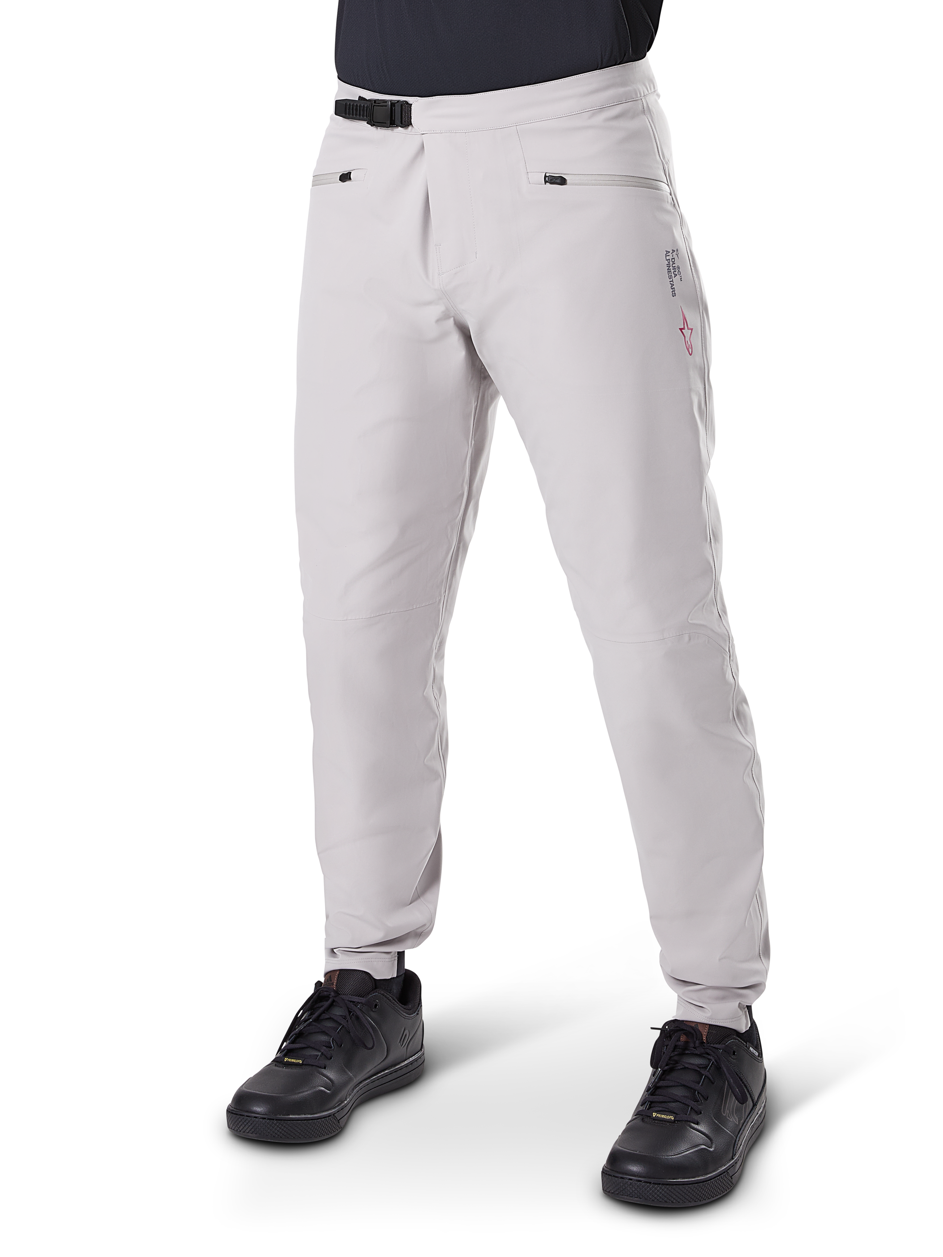 Alpinestars A-Dura Waterproof Pants, pantaloni impermeabili da mountain bike, grigio titanio, con chiusura a cricchetto nera in vita e tasche con zip, gambe affusolate con polsini elastici, indossati con scarpe nere, costruzione impermeabile 3L per ciclismo fuoristrada
