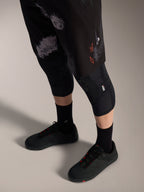 Alpinestars A-Dura Ride Shorts Black Camo, pantaloncini MTB con logo arancione, ginocchiere e scarpe tecniche.