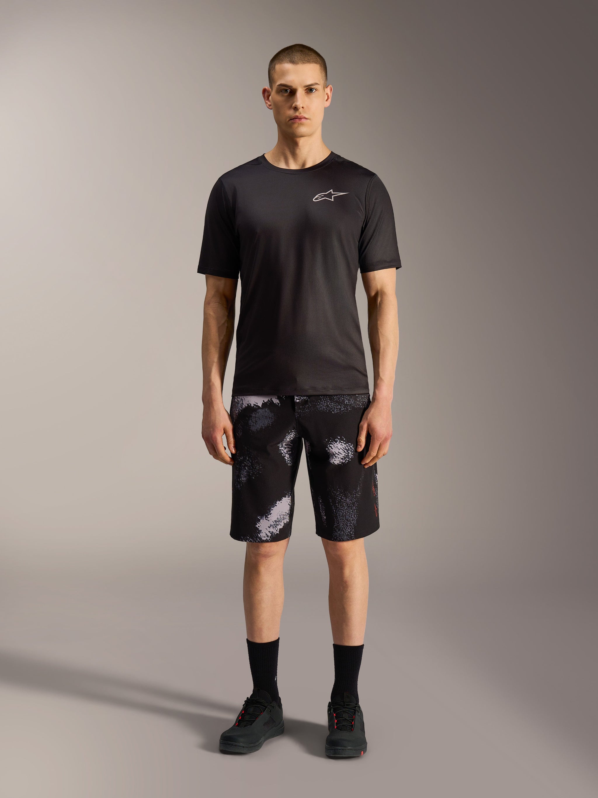 Pantaloncini Alpinestars A-Dura Ride Black Camo abbinati a t-shirt tecnica nera per versatilità in mountain bike.