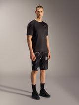 Alpinestars A-Dura Ride Shorts, pantaloncini MTB Black Camo con motivo mimetico grigio, maglia e scarpe nere.