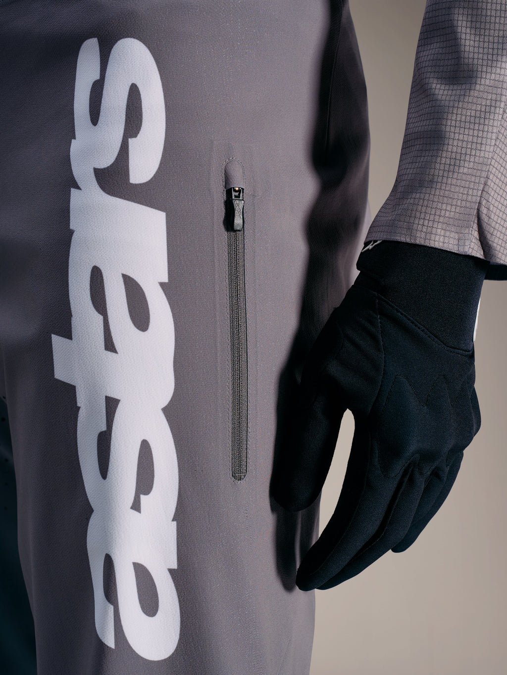 Pantaloni Alpinestars A-Supra Elite grigio sfumato, logo bianco e tasca con zip, abbigliamento tecnico per gare MTB.