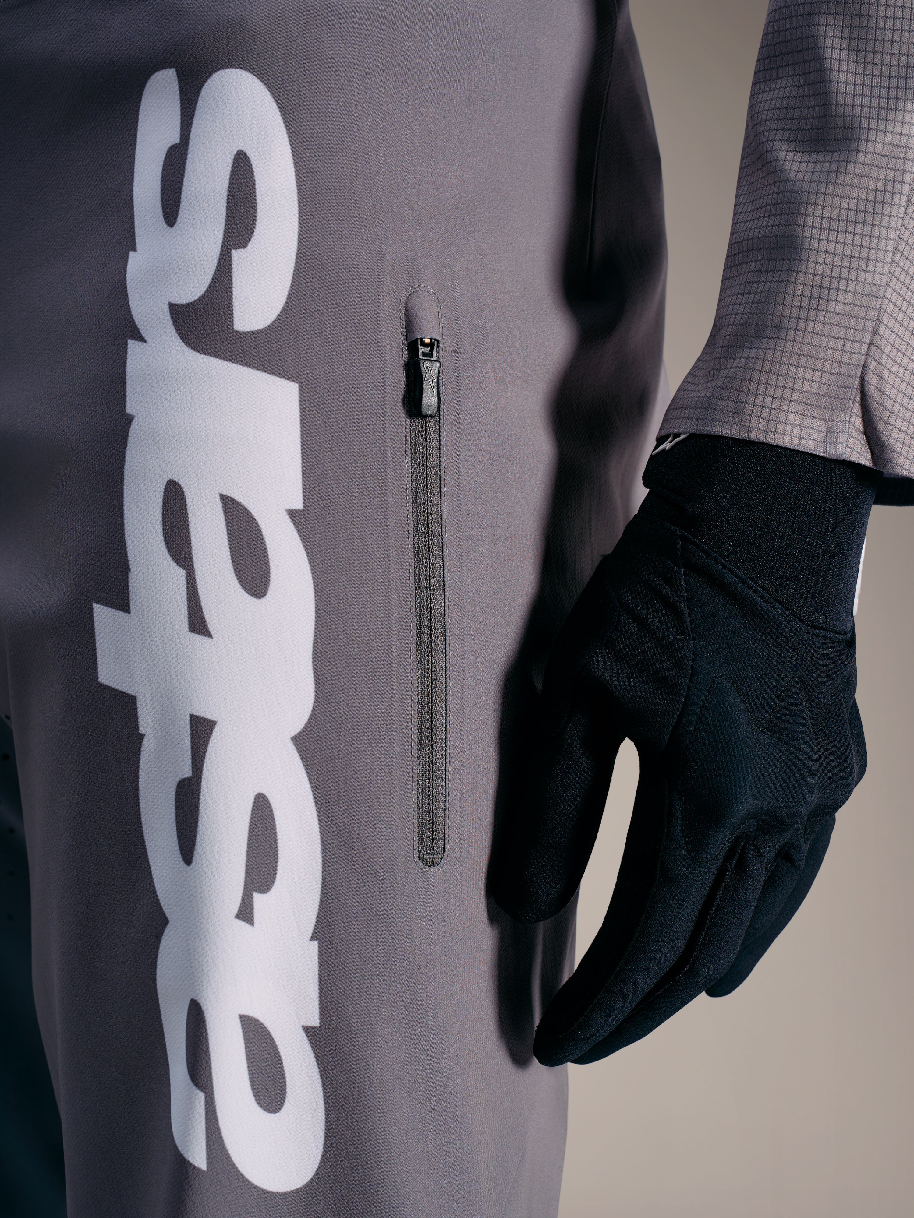 Pantaloni Alpinestars A-Supra Elite grigio sfumato, logo bianco e tasca con zip, abbigliamento tecnico per gare MTB.