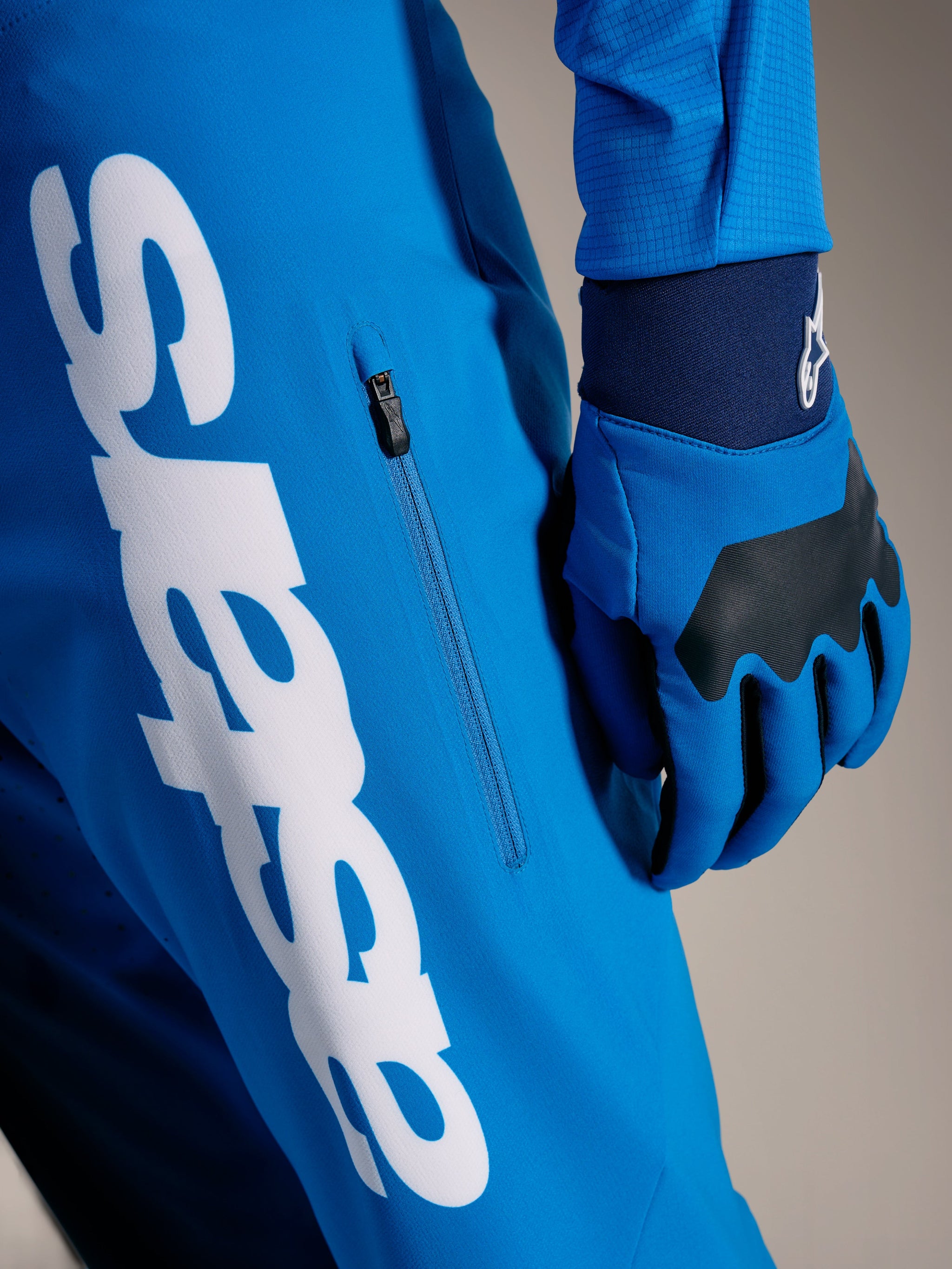 Pantaloni MTB A-Supra Elite Faded Bright Blue con grande scritta Astars bianca e tasca laterale con zip verticale.