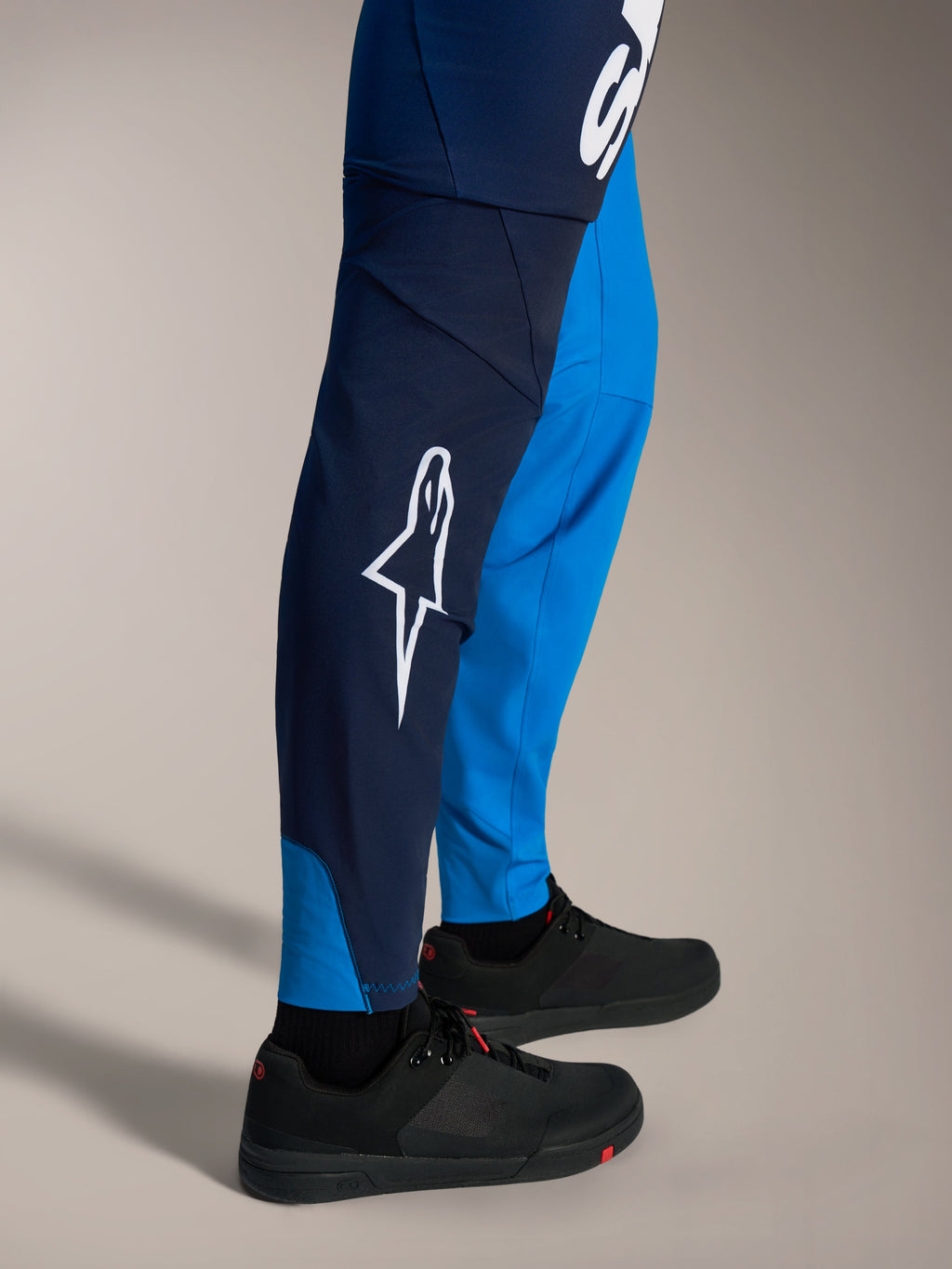 Pantaloni MTB Alpinestars A-Supra Elite blu sfumato con logo Astars bianco e vestibilità racing aderente.