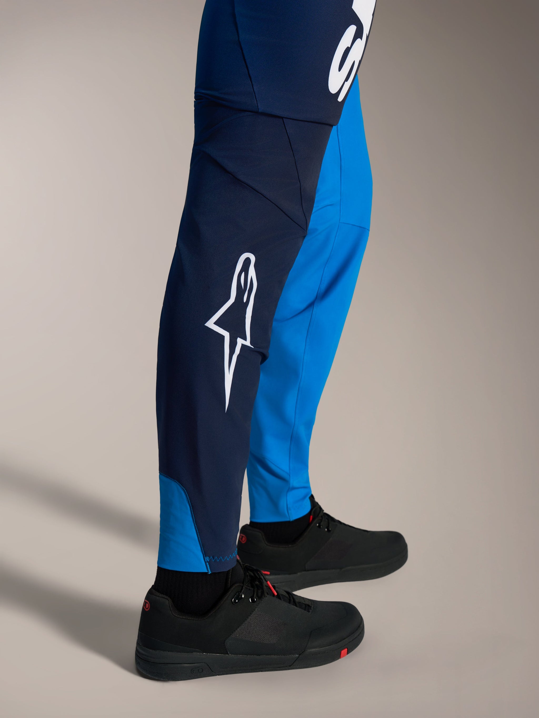 Pantaloni MTB Alpinestars A-Supra Elite blu sfumato con logo Astars bianco e vestibilità racing aderente.