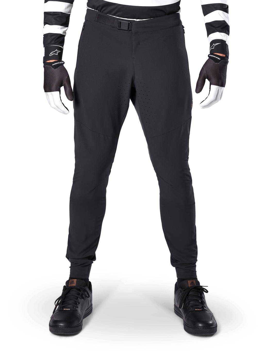 Alpinestars A-Aria Elite Pants, pantaloni da mountain bike, nero, vista frontale con perforazioni laser e chiusura con fibbia magnetica, indossati con maglia a righe bianche e nere e guanti neri, abbigliamento tecnico da ciclismo per trail riding