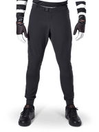Alpinestars A-Aria Elite Pants, pantaloni da mountain bike, nero, vista frontale con perforazioni laser e chiusura con fibbia magnetica, indossati con maglia a righe bianche e nere e guanti neri, abbigliamento tecnico da ciclismo per trail riding