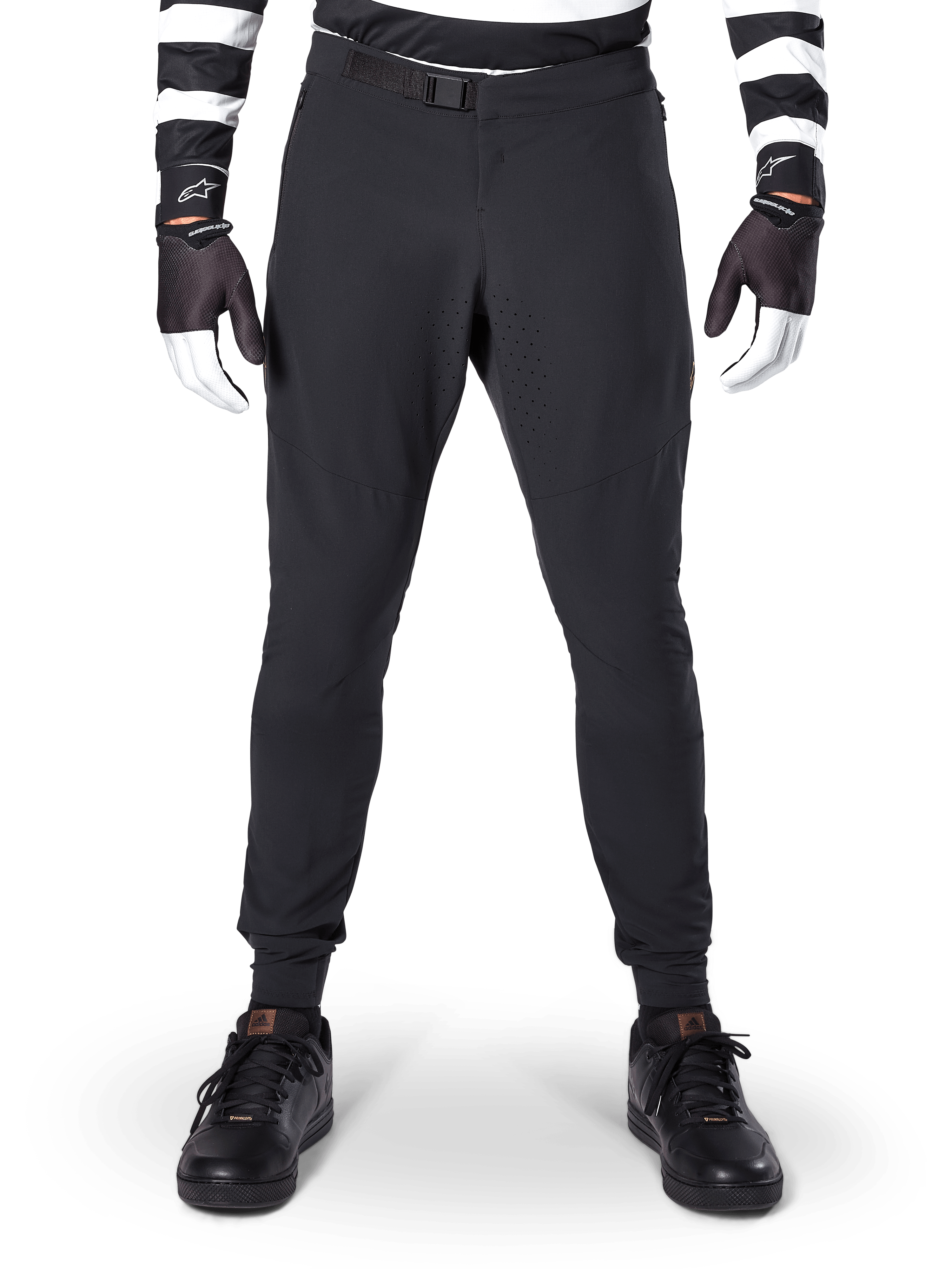 Alpinestars A-Aria Elite Pants, pantaloni da mountain bike, nero, vista frontale con perforazioni laser e chiusura con fibbia magnetica, indossati con maglia a righe bianche e nere e guanti neri, abbigliamento tecnico da ciclismo per trail riding