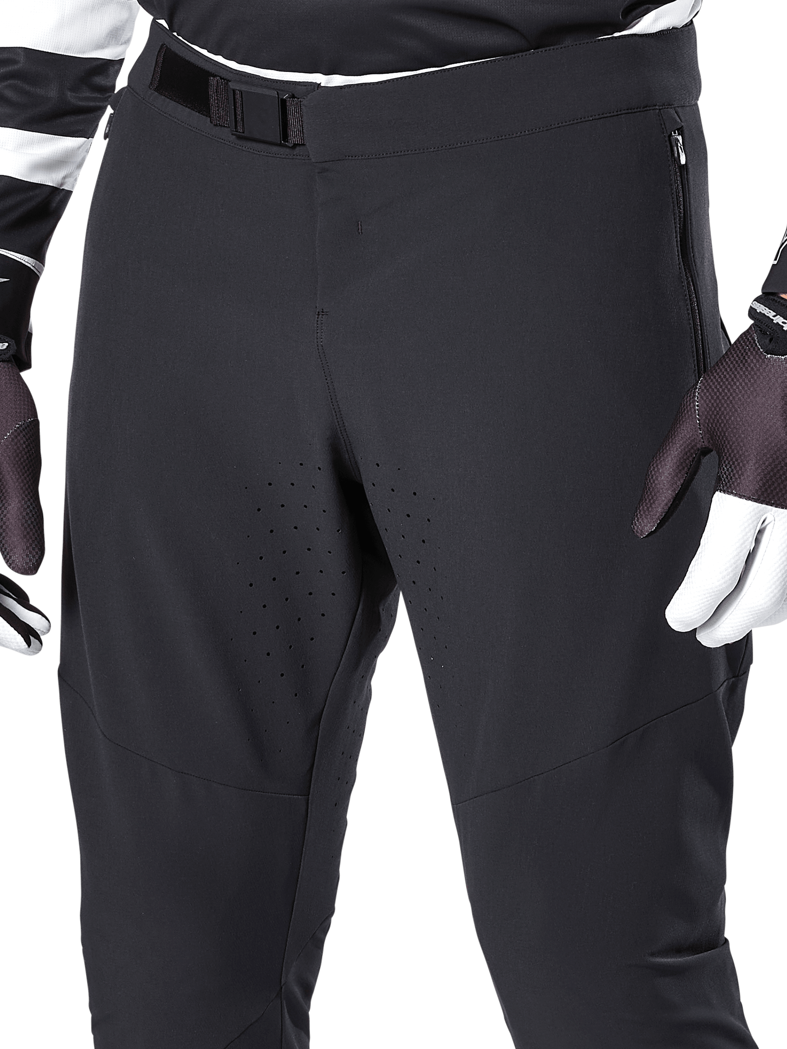 Alpinestars A-Aria Elite Pants, pantaloni da mountain bike neri, primo piano della vita e delle cosce con chiusura a fibbia magnetica e fori di ventilazione tagliati al laser, abbinati a guanti da ciclismo