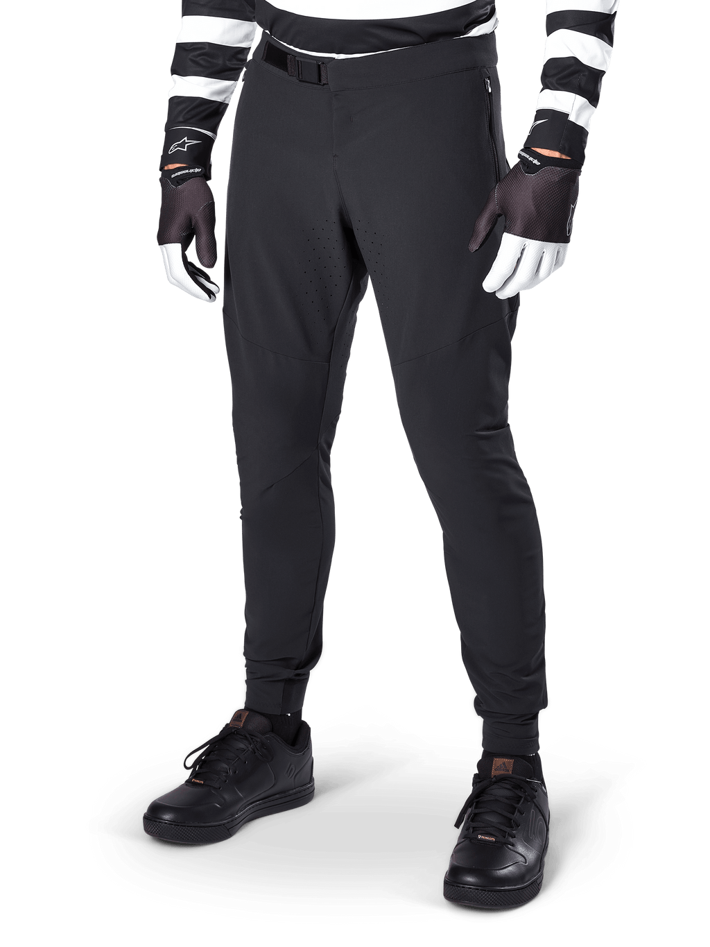 Pantaloni Alpinestars A-Aria Elite, pantaloni neri da mountain bike con ventilazione a taglio laser sulle cosce e chiusura con fibbia magnetica, indossati con maglia a righe bianche e nere e guanti, abbigliamento MTB ad alte prestazioni per il ciclismo fuoristrada
