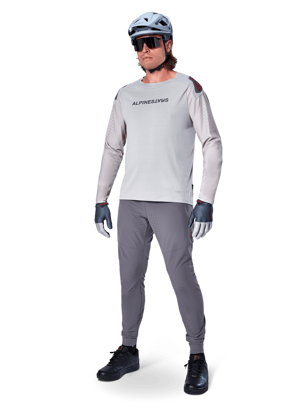 Pantaloni Alpinestars A-Aria Elite, pantaloni MTB grigio scuro, indossati da un rider con maglia a maniche lunghe grigio chiaro e casco grigio, con fori di ventilazione laser sulle cosce e vestibilità tecnica affusolata per mountain bike