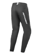 Pantaloni Alpinestars A-Dura Elite, pantaloni da mountain bike, nero, vista laterale posteriore con logo Alpinestars argento sulla coscia, tasca con zip e polsini elasticizzati, abbigliamento tecnico resistente per MTB