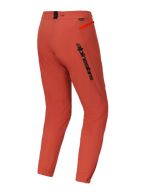 Pantaloni Alpinestars A-Dura Elite, pantaloni da mountain bike (MTB), arancione scuro, vista posteriore di tre quarti con logo Alpinestars nero sulla coscia, dettaglio cerniera arancione sul fianco e polsini elasticizzati, abbigliamento tecnico da ciclismo
