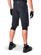 Vista posteriore di un rider che indossa i pantaloncini Alpinestars A-Aria Elite in nero, pantaloncini da mountain bike ad alte prestazioni, abbinati a guanti da ciclismo neri e scarpe nere, progettati per la flessibilità di movimento su percorsi fuoristrada