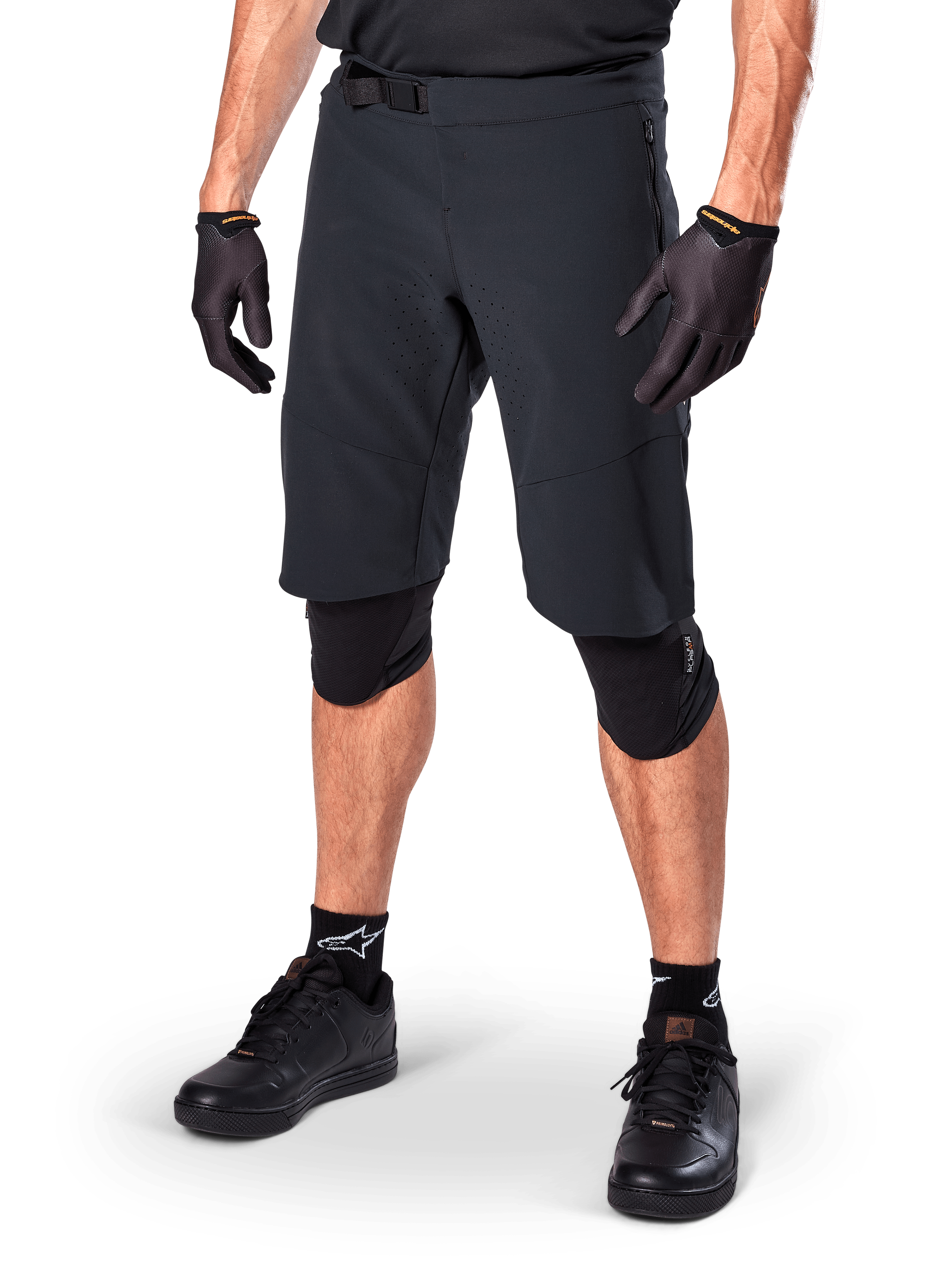 Alpinestars Pantaloncini A-Aria Elite, pantaloncini da ciclismo neri, indossati con guanti e ginocchiere neri coordinati, dotati di fibbia magnetica e perforazioni tagliate al laser, design essenziale per mountain bike fuoristrada